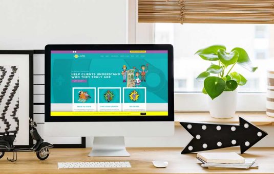 The Ignition! website homepage displayed on an iMac computer sat on a desk